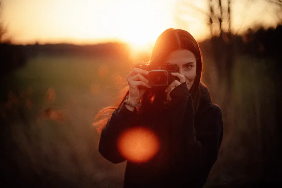 Kim mit Kamera im Sonnenuntergang
